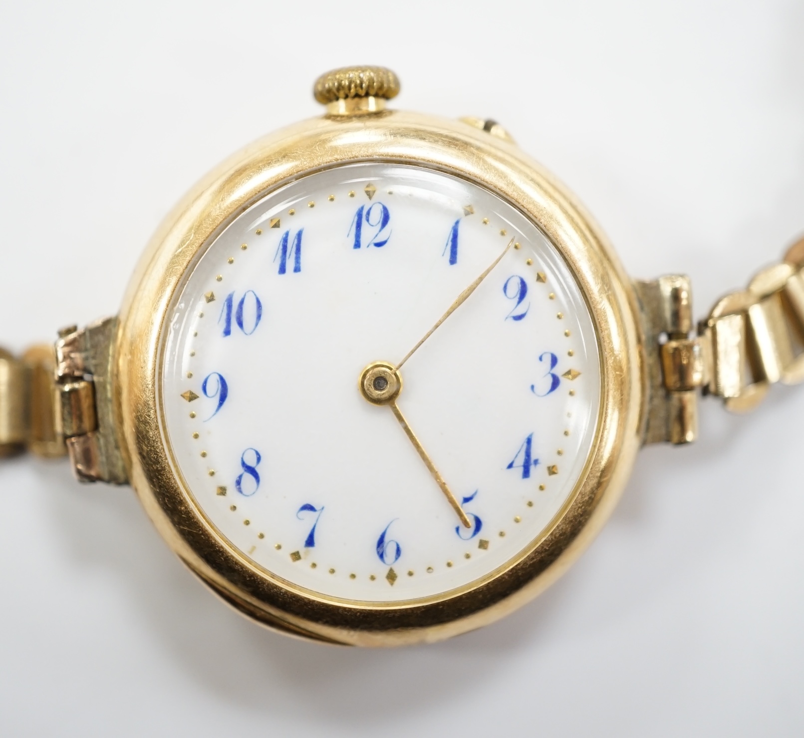 An early 20th century 15ct gold manual wind wrist watch, on a rolled gold bracelet.